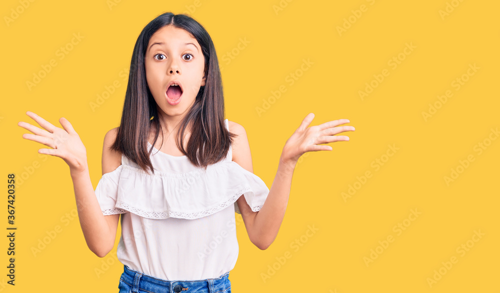 Beautiful child girl wearing casual clothes celebrating crazy and amazed for success with arms raised and open eyes screaming excited. winner concept Beautiful child girl wearing casual clothes celebrating crazy and amazed for success with arms raised and open eyes screaming excited. winner concept
