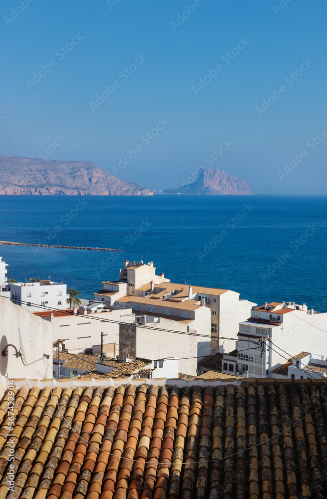 View over the white washed houses with acient roofs to the ocean and the rock of Calpe, Altea, Costa Blanca, Spain
