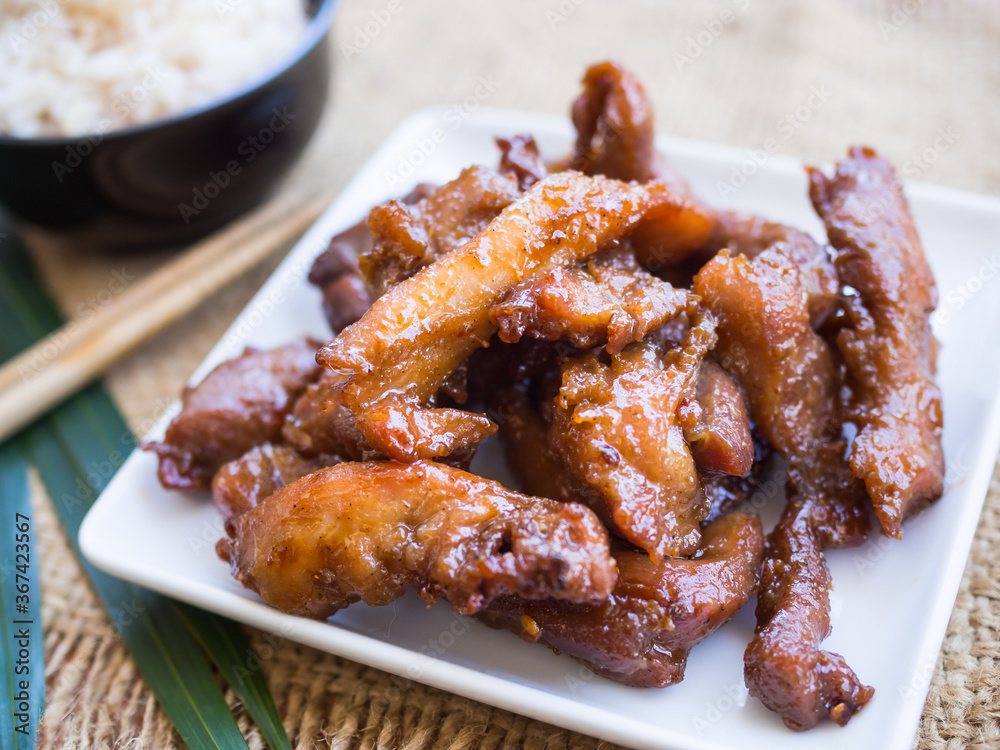 Fried pork on white plate on wood background. Thai food concept. Fried pork on white plate on wood background. Thai food concept.