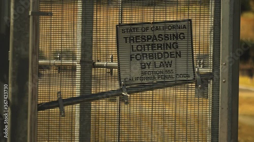 White sign with words state of California, trespassing loitering forbidden by law, section California penal code photo
