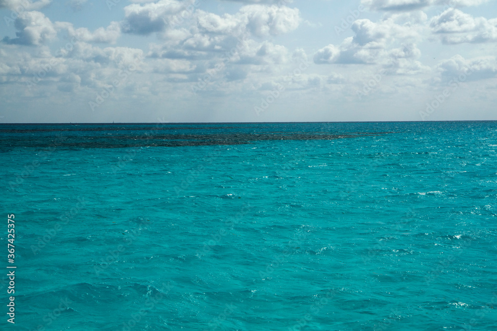 Natural texture. View of the turquoise color water ocean, sea waves and horizon in the Caribbean. 