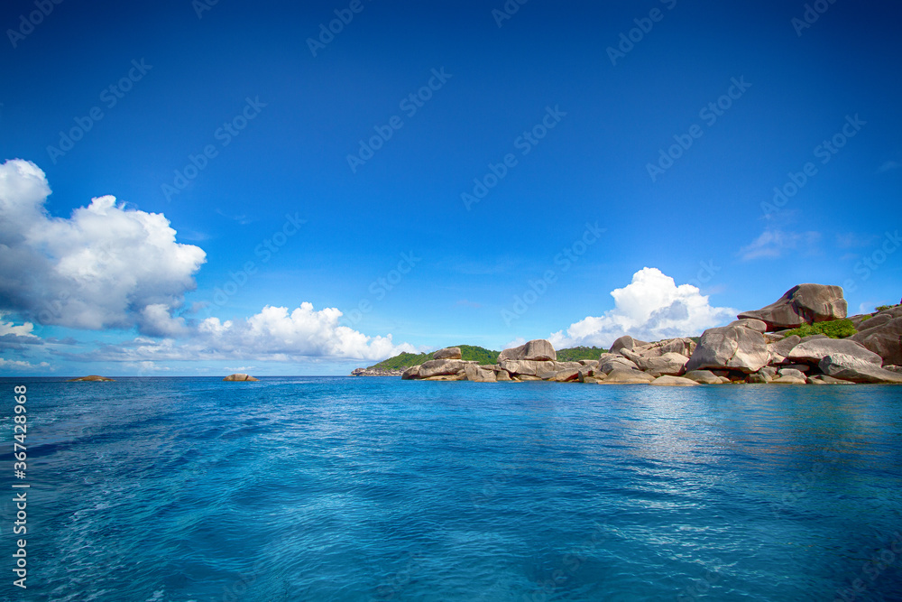 Asian rocky shore, emerald water and clouds