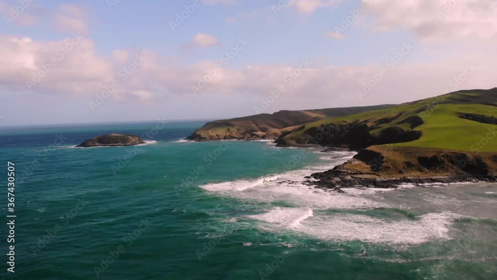 Puranakui coast, New Zealand aerial shot from the sea. Sea waving cliffs in sunny summer day, green land. Puranakui coast, New Zealand aerial shot from the sea. Sea waving cliffs in sunny summer day, green land.