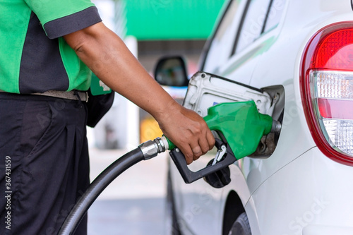 Fill the car with fuel. The car is filled with gasoline at a gas station by a gas station pump.