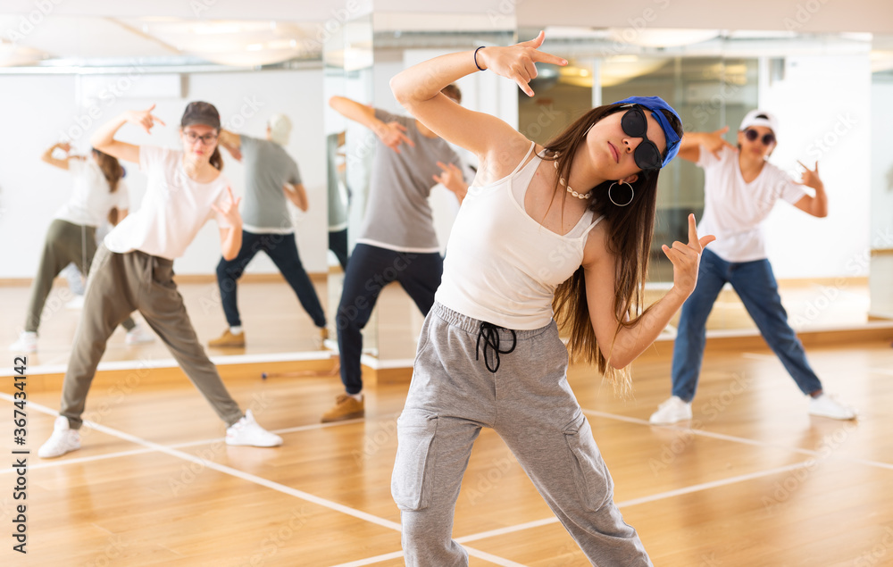 Teenagers boy and girls performing hip hop at group dance class