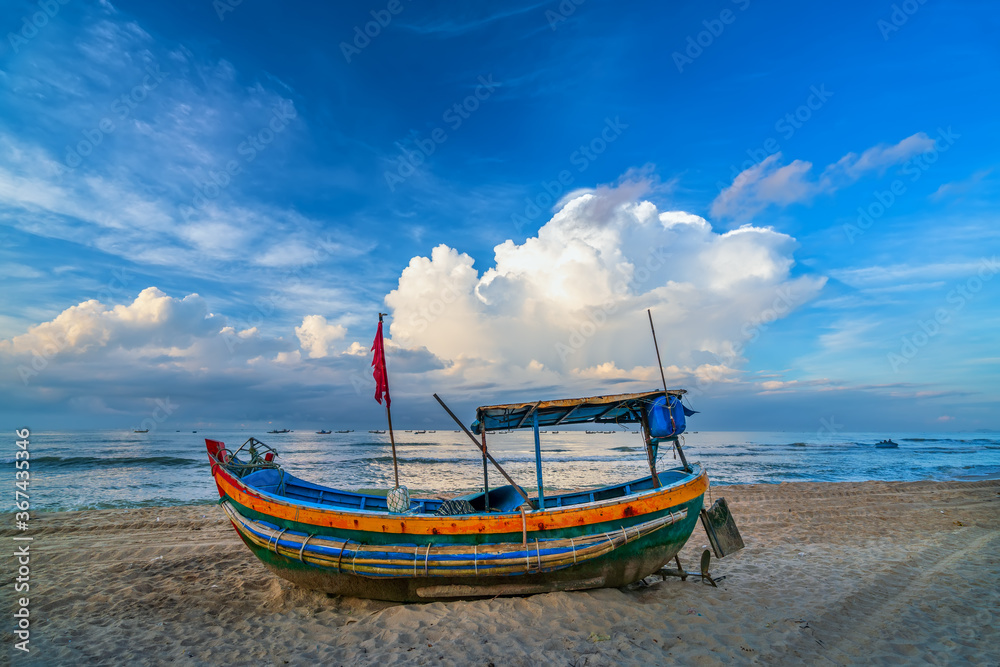 Fishing boat to dawn on the beautiful beach on a summer morning on a tropical beach near Mui Ne, Vietnam