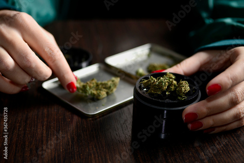 woman with weed in hands nails beautiful style grinder
