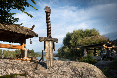 famous sword excalibur of King Arthur stuck in rock. Edged weapons from the legend Pro king Arthur. photo