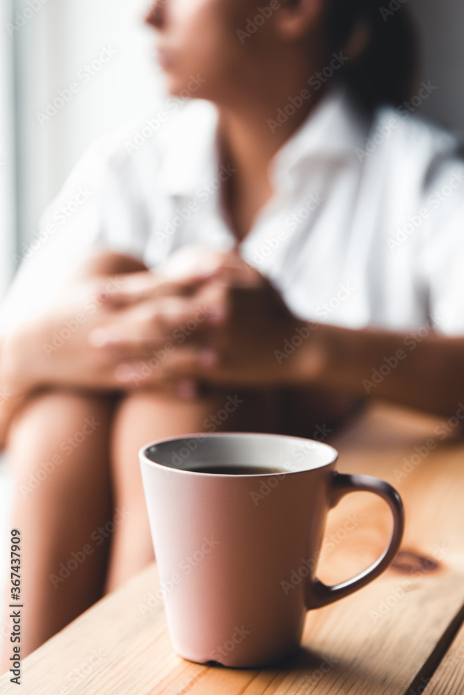 Woman in a white t-shirt holds morning coffee in a pink ceramic cup. Manicure. Front view Woman in a white t-shirt holds morning coffee in a pink ceramic cup. Manicure. Front view
