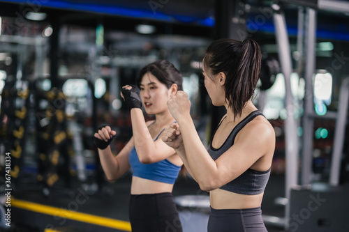 Sporty young asian women training boxer wearing strap on wrist with coach