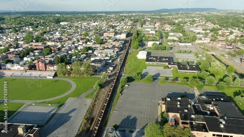 Aerial of a long train passing through American Lebanon city in Pennsylvania USA, train travel, coal industry theme photo