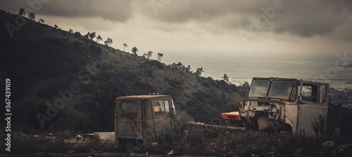 destroyed car on the background of mountains and sea