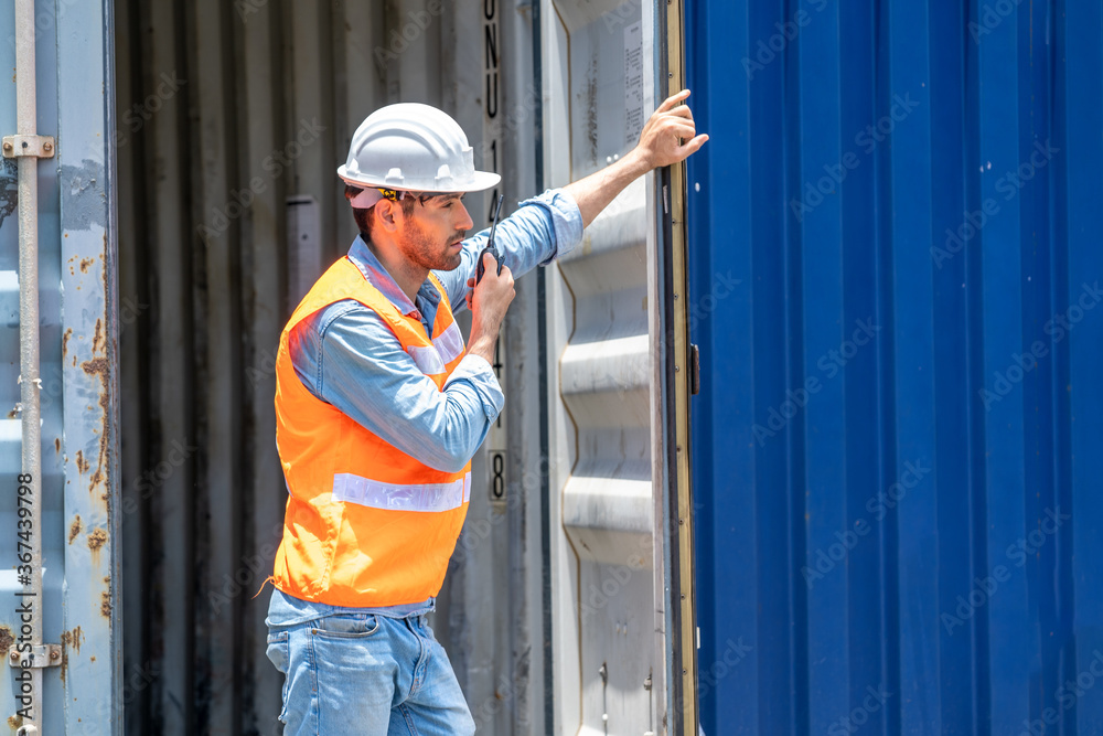Foreman worker talking on the walkie-talkie for controlling loading container in container warehouse. Foreman worker talking on the walkie-talkie for controlling loading container in container warehouse.
