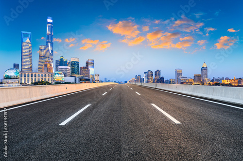 Empty asphalt road and city skyline and buildings at night in Shanghai China.