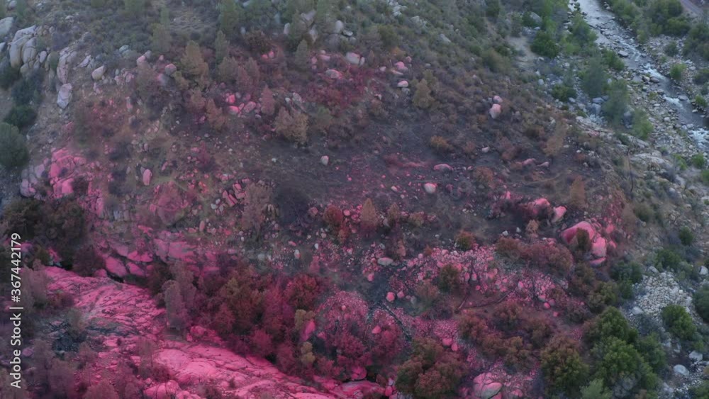 Red fire retardant chemicals dropped over mountain valley, wildfire prevention Red fire retardant chemicals dropped over mountain valley, wildfire prevention