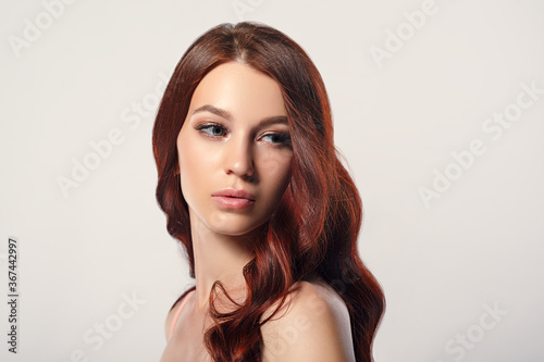 red-haired beautiful young woman on a light background