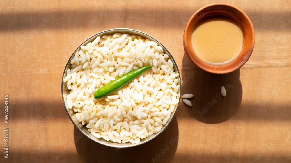 puffed rice and a green chili on a steel bowl with fresh hot tea on a wooden table top puffed rice and a green chili on a steel bowl with fresh hot tea on a wooden table top