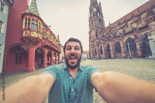 Canvas Print happy tourist takes selfie photo in Freiburg main square, Germany