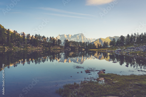 orange tent camping on lake arpy with view of grandes Jorasses with its main summits Pointe Walker and Pointe Whymper in the french alps of Mont Blanc. night view with comet in the starry sky photo