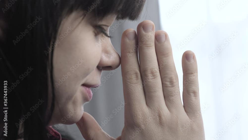 lifestyle brunette girl makes a wish prayers bedtime religion concept. prayer woman mom indoors praying by bed front of window lifestyle brunette girl makes a wish prayers bedtime religion concept. prayer woman mom indoors praying by bed front of window