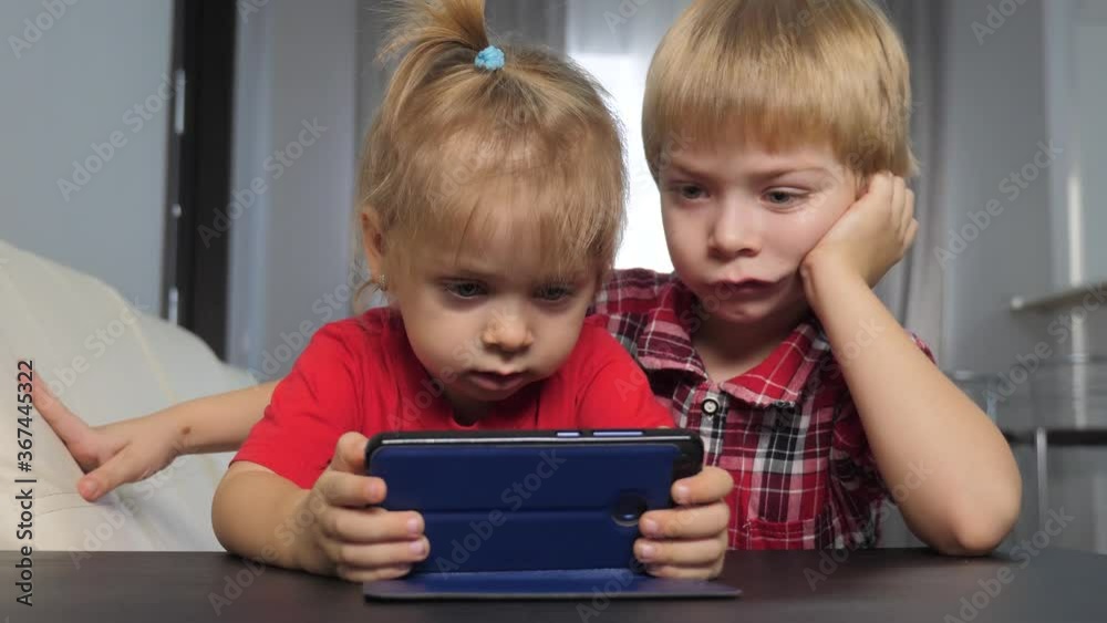 children watch online video on a smartphone. little boy and girl brother sister watch online streaming lifestyle broadcasting cartoons on the phone children watch online video on a smartphone. little boy and girl brother sister watch online streaming lifestyle broadcasting cartoons on the phone