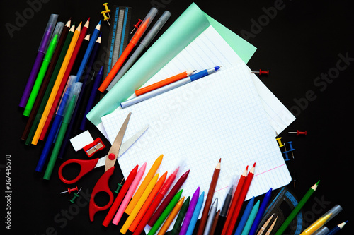 School and office supplies on blackboard background