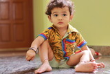 A child sitting on the ground inside the house