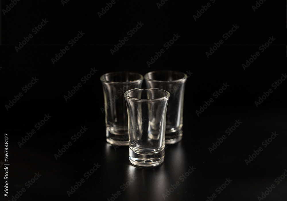 Empty shot glasses for alcohol cocktail on black background. Empty shot glasses for alcohol cocktail on black background.