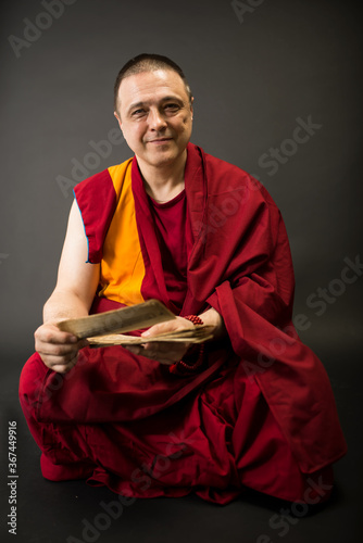 Konstfotografi Tibetan Buddhist monk teacher in a burgundy yellow outfit suit