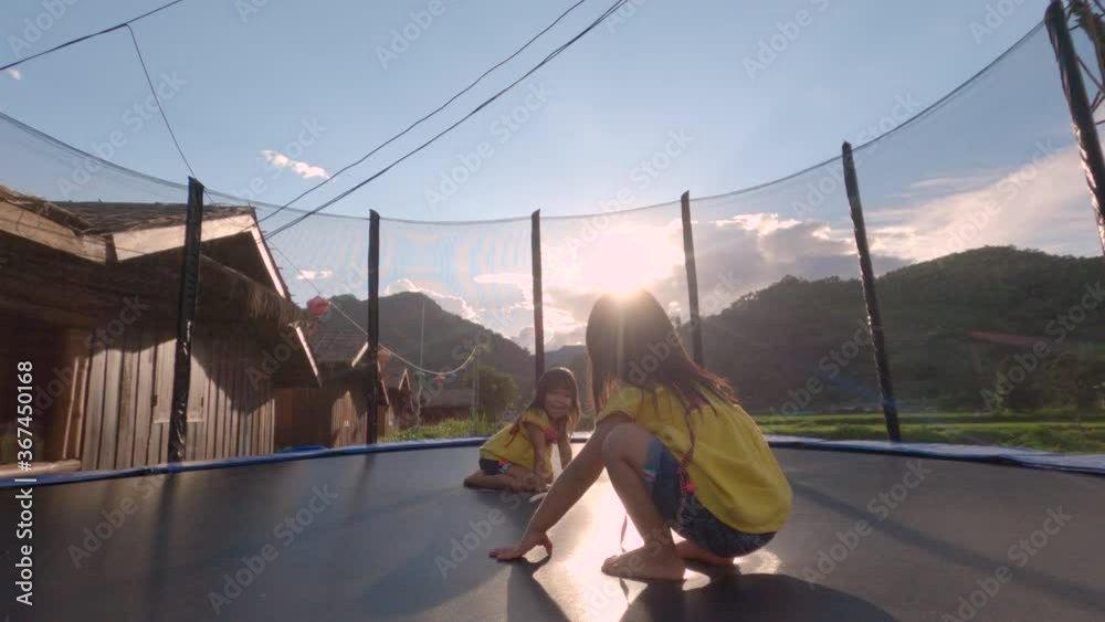 custom made wallpaper toronto digitalHappy child girls playing and jumping on trampoline outdoor at sunset. Family lifestyle on vacations.