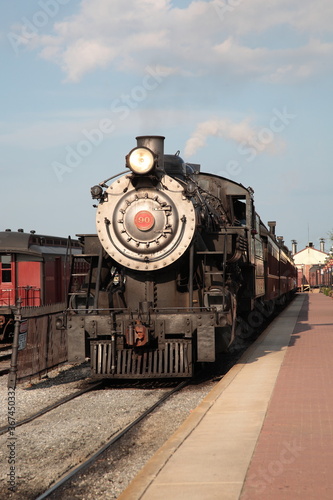 A smoke steam locomotive operated by the Strasburg Rail Road stops and awaits departure at the train station in Strasburg, Lancaster County, Pennsylvania. 