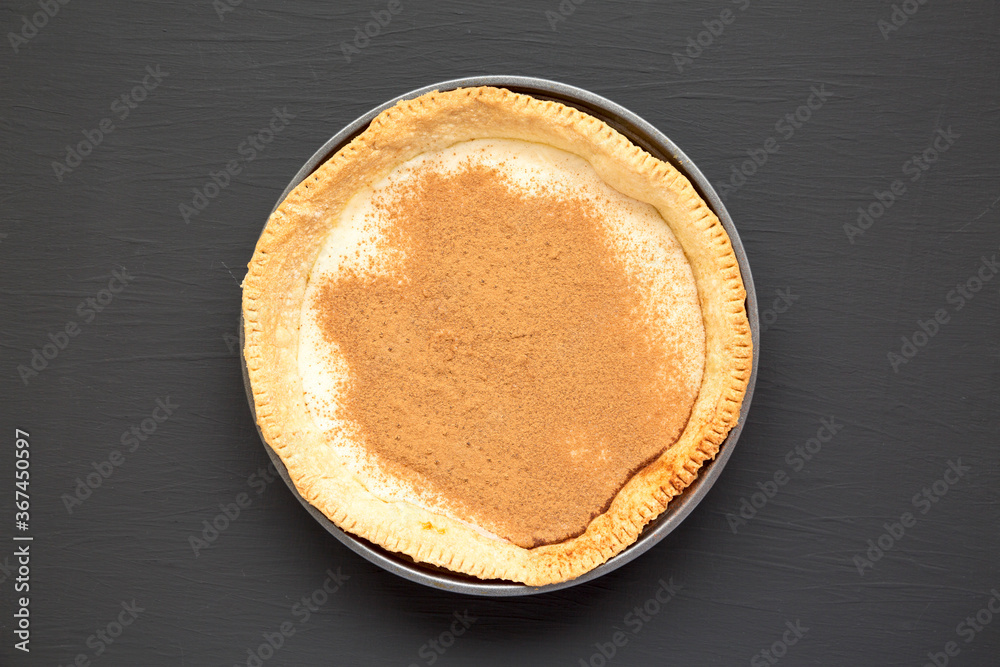 Homemade Sugar Cream Pie in a baking dish on a black background, top view. Overhead, from above, flat lay. Homemade Sugar Cream Pie in a baking dish on a black background, top view. Overhead, from above, flat lay.