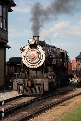 A smoke steam locomotive operated by the Strasburg Rail Road stops and awaits departure at the train station in Strasburg, Lancaster County, Pennsylvania. 