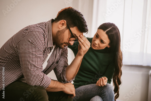 Man is sad and depressed, his wife is consoling him. © djoronimo