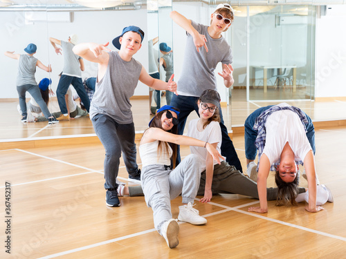 Group of dancing teenagers posing in dance studio. Hip hop dancers