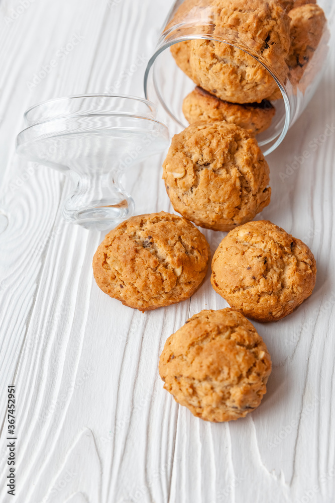 Homemade oatmeal cookies on white wooden table with milk on background Homemade oatmeal cookies on white wooden table with milk on background