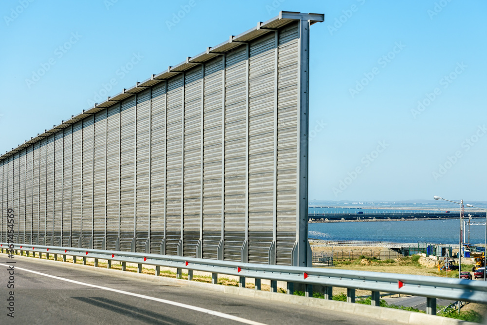 Sea view through the roadside fence. Sound-absorbing fence. Sea view through the roadside fence. Sound-absorbing fence.
