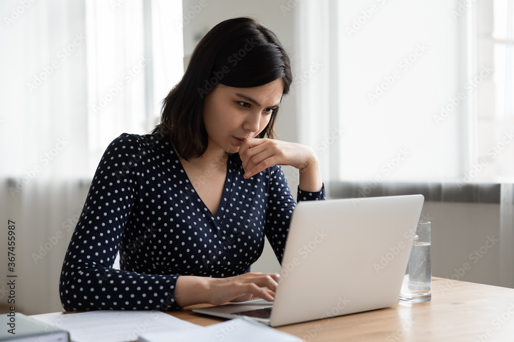 Thoughtful Vietnamese millennial girl sit at desk at home study online on laptop pondering of problem solution, pensive Asian young woman work with document on computer thinking contemplating Thoughtful Vietnamese millennial girl sit at desk at home study online on laptop pondering of problem solution, pensive Asian young woman work with document on computer thinking contemplating