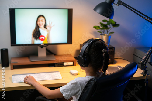 Portrait of happy Asian girl using video teleconference for online studying with her teacher at home. distance learning, online learning, technology or remote connection concepts