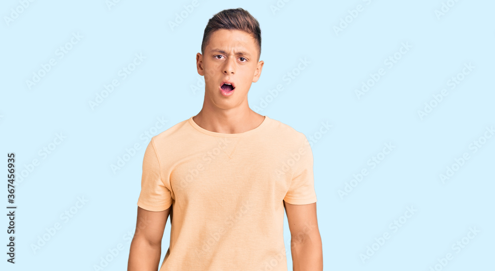 Fototapeta premium Young handsome man wearing casual clothes in shock face, looking skeptical and sarcastic, surprised with open mouth