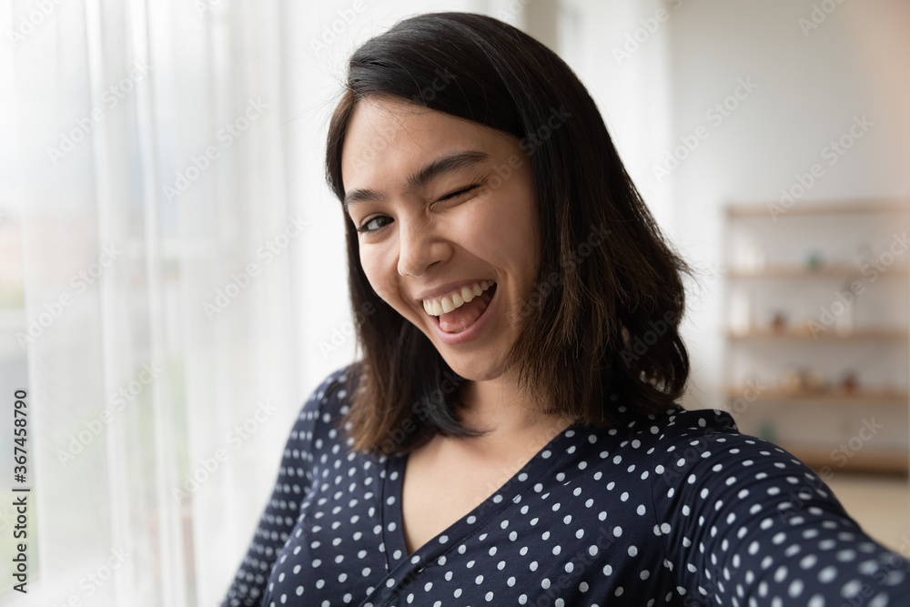 Self-portrait of funny happy millennial Asian girl have fun posing for photo on good quality smartphone camera at home, excited smiling Vietnamese young woman take selfie on modern cellphone gadget Self-portrait of funny happy millennial Asian girl have fun posing for photo on good quality smartphone camera at home, excited smiling Vietnamese young woman take selfie on modern cellphone gadget