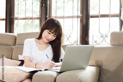 Asian teenager woman work and study online via internet at home.