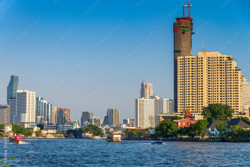 cityscape of Bangkok city skyline with river and blue sky background, Bangkok city is modern metropolis of Thailand and favorite of tourists