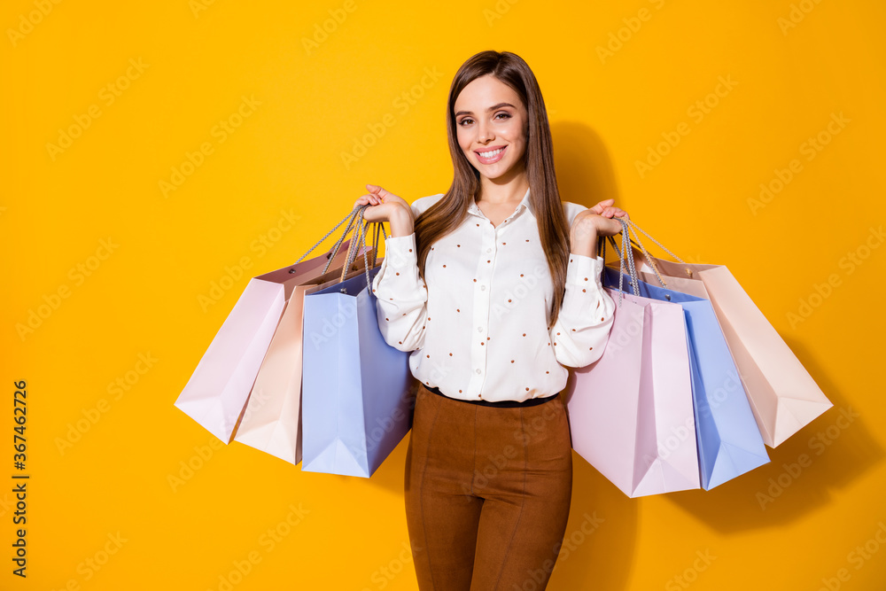 Portrait of her she nice-looking attractive pretty fashionable cheerful cheery brown-haired girl carrying new things season clothes clothing isolated bright vivid shine vibrant yellow color background