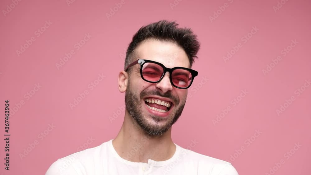close up of a young sexy man wearing sunglasses, turning his head from side to side, saying no, smiling wide, laughing out loud, yelling with all his strength, yawning and swallowing something on pink close up of a young sexy man wearing sunglasses, turning his head from side to side, saying no, smiling wide, laughing out loud, yelling with all his strength, yawning and swallowing something on pink