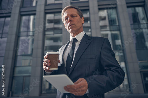 Handsome man holding tablet computer and cup of coffee