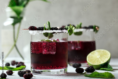 Bramble cocktail with blackberries and crashed ice