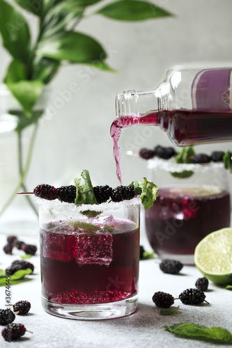 Bramble cocktail with blackberries and crashed ice