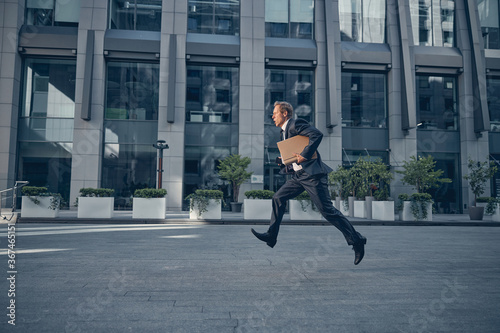 Handsome businessman running fast on the street