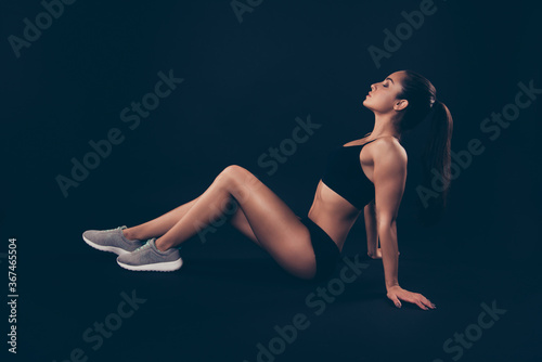 Profile side view of her she nice-looking attractive sportive feminine gorgeous lady sitting on floor perfect form shape figure line enjoying healthy life isolated over black background